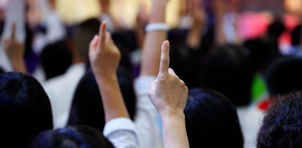 Crowd of people raising fingers in the air