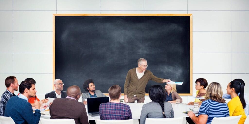A man explaining something to the peoples on the table